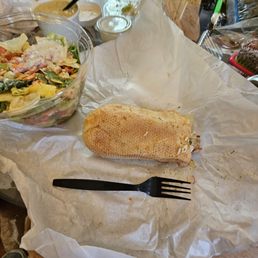a sandwich and salad on a table a sandwich and salad on a table