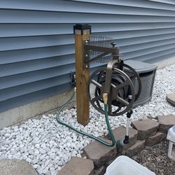 Bedrock Home & Property - Custom single-post hose reel holder: stained, concreted, mounted, and fully set up.