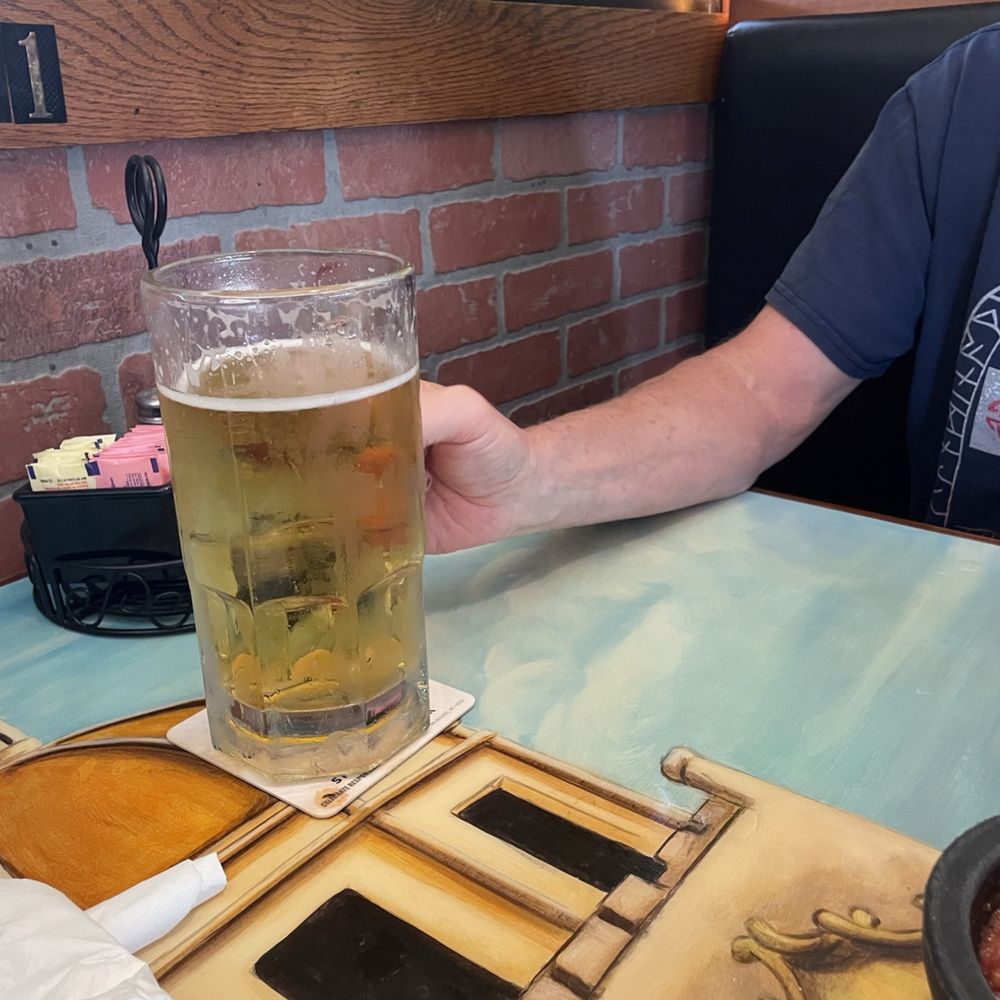 Casa Martini - a man holding a glass of beer - Mexican Near Me - Dry Ridge, Kentucky