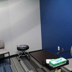 Binson's Medical Equipment and Supplies - A private consultation and fitting room at the Dearborn medical supply store, with a blue accent wall, chairs, and a small ta...