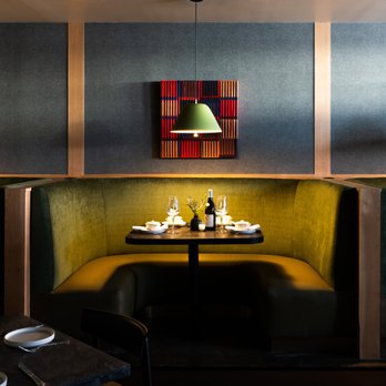 AT Bistro - Au Troisieme - a booth with a table and chairs - New American Near Me - Dallas, Texas
