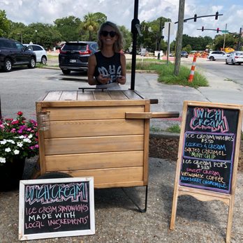 Wich Cream - a woman behind a table with a sign - Street Vendors Near Me