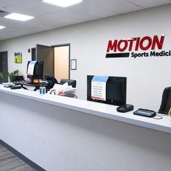 MOTION Sports Medicine - Nyack - Modern reception area at MOTION Nyack featuring front desk, seating, and branded signage in a bright, professional setting.