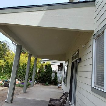 Upscale Renovations - a porch with a bench on the side of the house - General Contractors Near Me