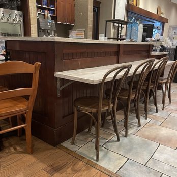 la Madeleine - Bar area seating but the wine bottles are definitely dusty . - Cafes Near Me - Austin, Texas