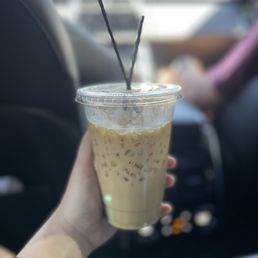 a hand holding a cup of iced coffee