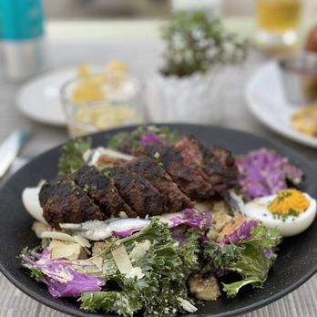 Nicolas Eatery - Kale Caesar salad with sardines and added hanger steak - French Near Me - Los Angeles, California