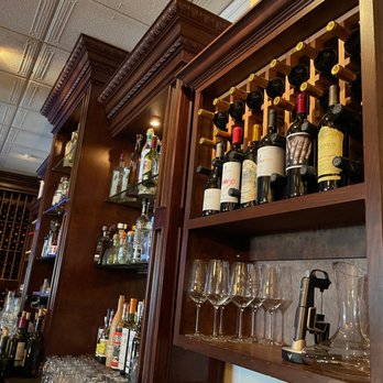 Romesco Mexiterranean Bistro - a man standing in front of a wall of wine bottles - Mexican Near Me - Bonita, California Romesco Mexiterranean Bistro - a man standing in front of a wall of wine bottles - Mexican Near Me - Bonita, California