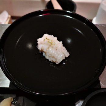 Kappo Masa - a black plate with a piece of rice on it - Sushi Bars Near Me - New York, New York