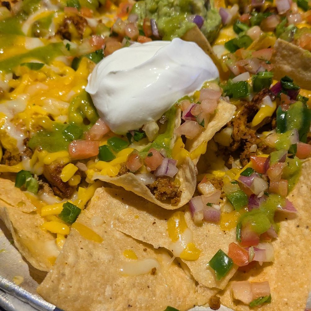 Appetizer nachos with chicken, chorizo, and guac