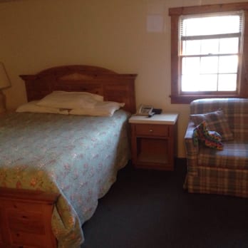 Barbee Hotel & Grill - The bed and love seat in the room. - Bars Near Me - Warsaw, Indiana
