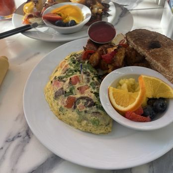 Immigrant Son Caffe - Farmer's Market omelette with fresh fruit, potatoes and toast with jam. Behind that, Eggs Benedict and their special Bloody Mary. - Breakfast & Brunch Near Me - Oxnard, California