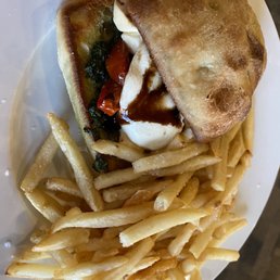 Caprese Sandwich - A plate features a fried sandwich with a side of French fries and a small salad with tomatoes and greens.