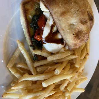The View Pub - Caprese Sandwich - A plate features a fried sandwich with a side of French fries and a small salad with tomatoes and greens. - New American Near Me - Burke, Vermont