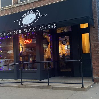 Baraboo's on Main - Baraboo's on Main, a tavern established in 2022, features a black awning with its logo and name, a neon "Open" sign, and festive string lights in the window. - Pubs Near Me - Dubuque, Iowa