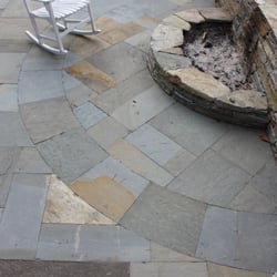Morning Dew Landscaping & Stonework - A custom cut, no joint, bluestone patio with surrounding walls and raised fire pit surrounding a pool.