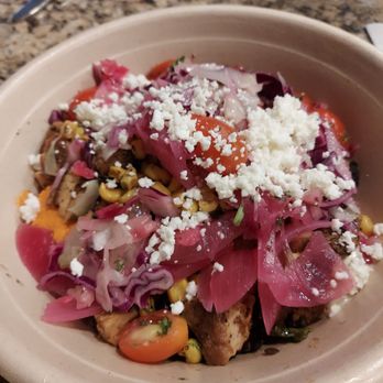 CAVA - A grain bowl with chicken, harissa hummus, pickled onions, feta, corn, tomatoes, and garlic dressing on the side. - Mediterranean Near Me - Westminster, Colorado