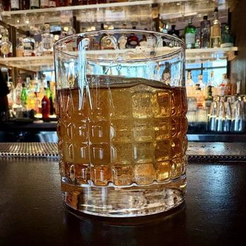 Bar 54 - Heavy pour of a great top shelf bourbon over a large ice cube - Cocktail Bars Near Me - New York, New York