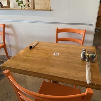 Bloom - a wooden table and orange chairs - Coffee & Tea Near Me - Los Angeles, California