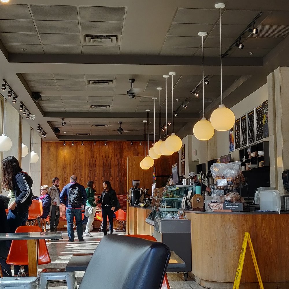people walking through a coffee shop