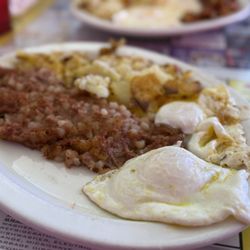 Corned beef hash with potatoes and eggs over medium