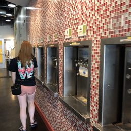 a woman standing in front of a row of soda machines