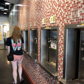 Spoon Me - a woman standing in front of a row of soda machines - Juice Bars & Smoothies Near Me - Rolla, Missouri