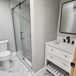 Gerard Remodeling - Bathroom remodel with marble-look tile, glass shower, and modern vanity design.