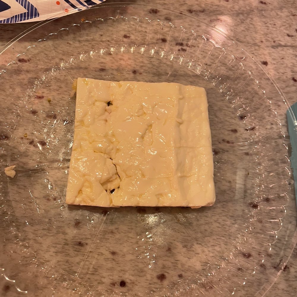 a square of cheese on a plate a square of cheese on a plate