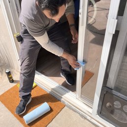 This is Juan cleaning up the door frame after replacing the track and rollers under this sliding glass door