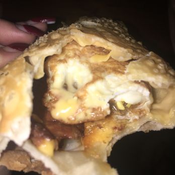 Bakery Makel - Breakfast empanada. Fried egg with cheese folded up on the right. Small piece of bacon on left side in giant air bubble. - Desserts Near Me - Clearwater, Florida