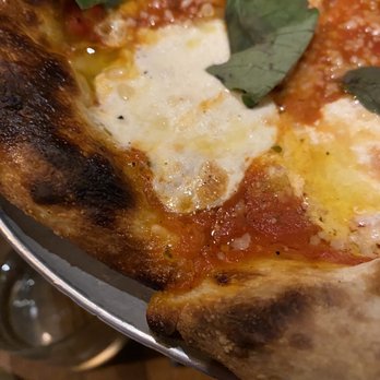 Prairie Fire - Margherita pizza - A close-up image of a Margherita pizza featuring melted cheese, tomato sauce, and basil leaves, served on a metal tray. - Pizza Near Me - Brookline, Massachusetts