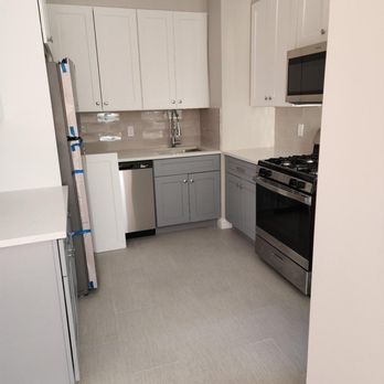 Andes B Construction - a kitchen with white cabinets and stainless steel appliances - General Contractors Near Me