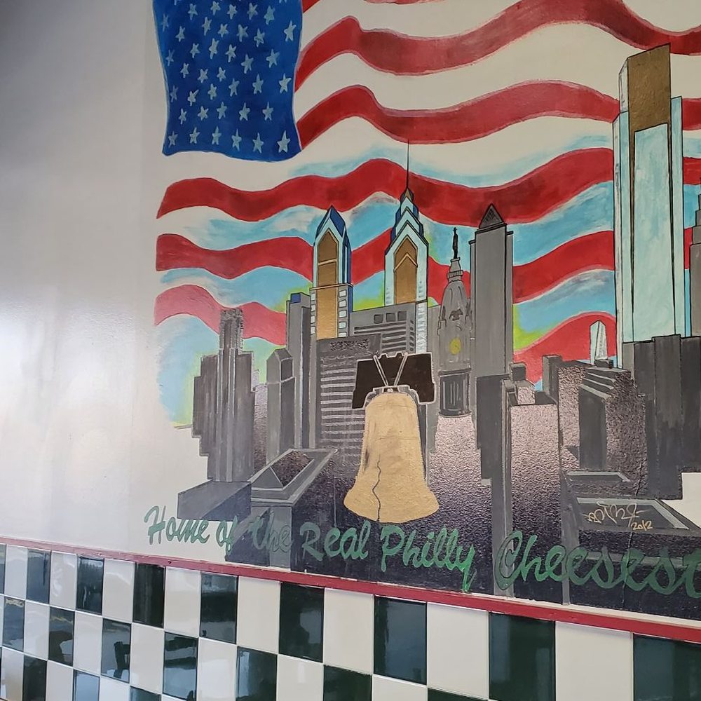 Taste of Philly - a mural of a flag and a bell - Sandwiches Near Me - Aurora, Colorado Taste of Philly - a mural of a flag and a bell - Sandwiches Near Me - Aurora, Colorado