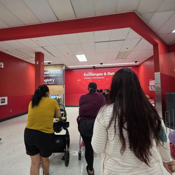 Target - Several women are standing in line at a currency exchange and refund counter inside a retail store, with a red wall and signage in the background. - Department Stores Near Me - Rosemead, California
