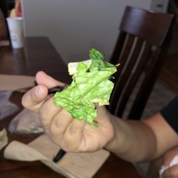 a person holding a piece of lettuce