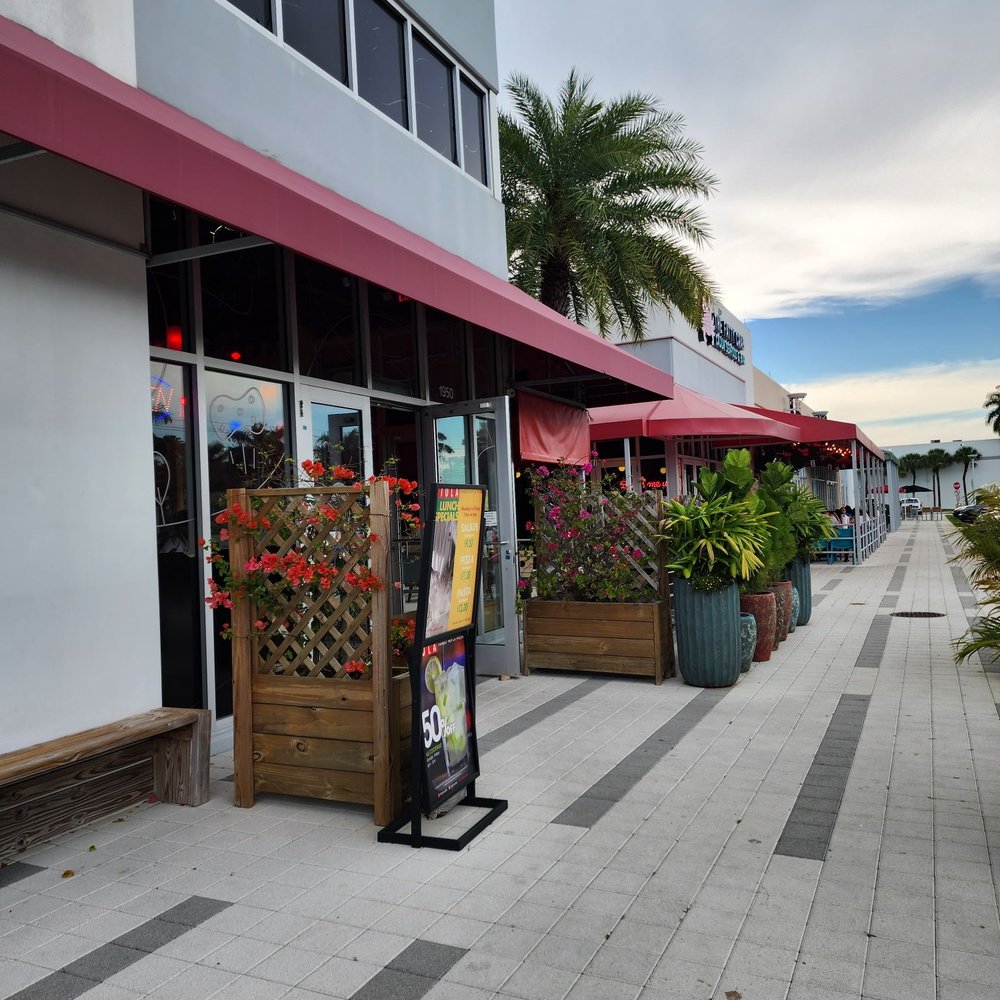 Piola - the outside of a restaurant with tables and umbrellas - Pizza Near Me - Doral, Florida Piola - the outside of a restaurant with tables and umbrellas - Pizza Near Me - Doral, Florida