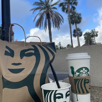 Starbucks - a starbucks cup and a paper bag on a table - Coffee & Tea Near Me - St. Augustine, Florida