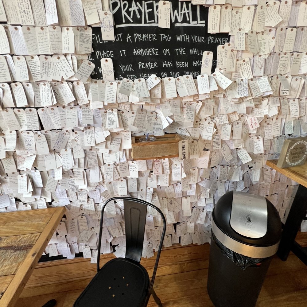 Charis Coffee - Prayer/art work wall in the shop!! - Coffee & Tea Near Me - Manteo, North Carolina