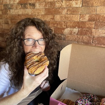 Grounds Donut House - Churro donut (eating ) -inside the box are chocolate frosted & strawberry frosted. - Donuts Near Me - Danbury, Connecticut