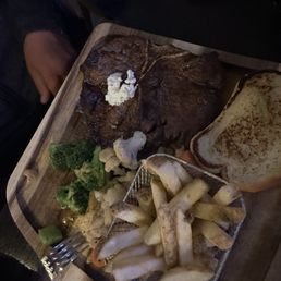 Medium well T-bone steak with fries side side of vegetables Medium well T-bone steak with fries side side of vegetables