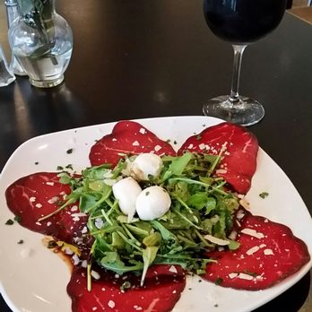 Lucky's Puccias - Plate of Brasada (air cured Italian ham) with fresh mozzarella and Arugula and a glass of house red. - Sandwiches Near Me - Austin, Texas Lucky's Puccias - Plate of Brasada (air cured Italian ham) with fresh mozzarella and Arugula and a glass of house red. - Sandwiches Near Me - Austin, Texas