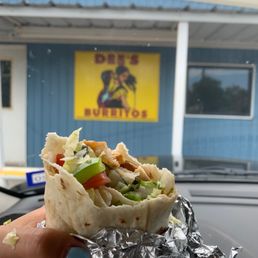 a hand holding a burrito