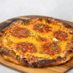Goldpie margie pizza. Red sauce base, parmigiano reggiano, mozzarella, and provolone. Finished with olive oil, pecorino romano, and basil.