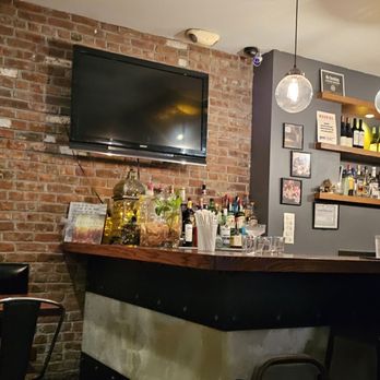 Rasa - a bar with a brick wall and a television - Malaysian Near Me - New York, New York