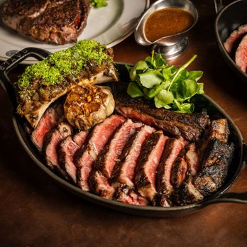 Hawksmoor - A dish of Steak and confit Garlic with greens and bone marrow - Steakhouses Near Me - Boston, Massachusetts Hawksmoor - A dish of Steak and confit Garlic with greens and bone marrow - Steakhouses Near Me - Boston, Massachusetts