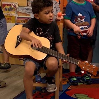 Toad Hall Childrens Center - 3 year old holding guitar - Preschools Near Me - Bradenton, Florida Toad Hall Childrens Center - 3 year old holding guitar - Preschools Near Me - Bradenton, Florida