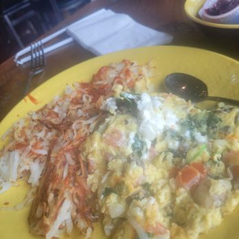 Jelly - This is the spinach omelet.  It tasted rancid. My husband tried it, and the aftertaste was overwhelming.  We were not charged for this. - A breakfast dish featuring scrambled eggs with vegetables and a side of hash browns on a yellow plate, set on a wooden table. - Breakfast & Brunch Near Me - Dyer, Indiana