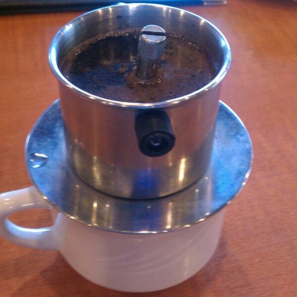 Miss Saigon - Vietnamese iced coffee, pre-ice. Comes to your table in this French drip filter. - Vietnamese Near Me - Tucson, Arizona Miss Saigon - Vietnamese iced coffee, pre-ice. Comes to your table in this French drip filter. - Vietnamese Near Me - Tucson, Arizona