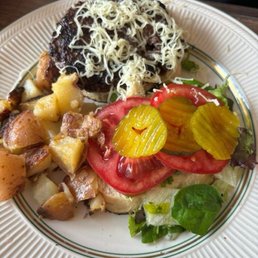 Burger on Sourdough bun with side of skillet potatoes Burger on Sourdough bun with side of skillet potatoes